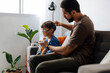 © kleberpicui - Father assisting young child during nebulizer therapy at home, showing parental care, pediatric respiratory treatment and emotional family support.