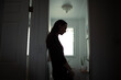 © kieferpix - silhouette of tired woman leaning against wall in bathroom, stress and mental health concept