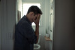 © kieferpix - stressed man standing in bathroom covering face with hands, mental health crisis concept