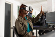 © DC Studio - African american developer uses vr glasses to navigate 3D coding interface. Black woman works at innovative company, analyzing software scripts and applying virtual technology for development projects