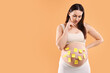 © New Africa - Thoughtful pregnant woman with notes with different names on her belly against orange background, space for text