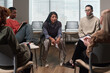 © pressmaster - Multiethnic group of middle aged women and young adult women sitting in circle participating in support group session, some taking notes, one woman appearing to share personal story