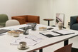 © pressmaster - Modern office table displaying documents, charts, pens, coffee cups and stationery, suggesting business meeting preparation or collaborative workspace in contemporary corporate environment