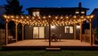 © Cherrin - Outdoor wooden patio deck with string lights glowing on a modern house at night