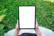 © Farknot Architect - Top view mockup image of a woman holding digital tablet with blank desktop white screen in the green yard