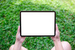 © Farknot Architect - Top view mockup image of a woman holding digital tablet with blank desktop white screen in the green yard