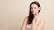 © kitthanes  - A beautiful young woman with clean, fresh skin against a beige background. Skincare, facial treatment, cosmetology, beauty, and spa. An elegant portrait of an woman.