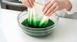 © Wool World - Person dyeing fabric green for St. Patricks Day on white table