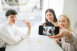 © Westend61 - Happy friends taking selfie in a restaurant