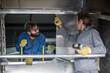 © Westend61 - Two men discussing inside of steel container in factory