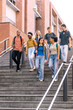 © Koldo_Studio - Diverse group of young students walking down urban university stairs together, enjoying college life and education
