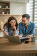 © Miljan Živković - Couple managing finances in kitchen with credit card