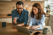© Miljan Živković - Young couple managing household finances and online shopping together
