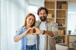 © Dragana Gordic - Smiling Couple Making Heart Gesture Together At Home Showing Love And Affection