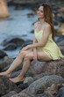 © zhagunov_a - Woman in yellow dress sitting on seaside rocks