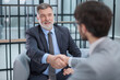© ASDF - Two men shaking hands in a business setting