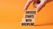 © Drago Designer - A hand arranging wooden blocks to spell out the importance of discipline in achieving success.