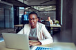 © Marko Geber - Confident businesswoman working on laptop in modern open plan office