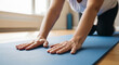© imagemir - Middle-aged Caucasian Woman Practices Yoga on a Blue Mat, Focusing on Her Breathing in a Serene Indoor Setting