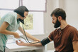© dsheremeta - Nurse checking man's blood pressure in clinic