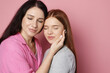 © New Africa - Mother and her teenage daughter on pink background. Space for text