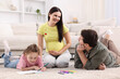 © New Africa - Pregnant woman, her husband and daughter drawing together on floor at home