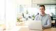 © ryker - Young professional man working on laptop in bright modern office with natural light and plants, confident expression capturing productivity and calm atmosphere