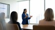 © ryker - Indian woman team leader giving expressive presentation to colleagues in modern conference room, confident gesture and engaged audience in natural light
