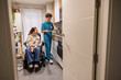 © PintoArt - Caregiver cooking for woman with disability in kitchen