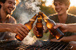 © InfinityVisuals - Cheers to Good Times: Friends celebrate a moment of camaraderie around a barbecue, beer bottles clinking in a toast to friendship and the joy of simple pleasures.