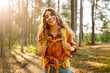 © maxbelchenko - Portrait of a young woman with a hiking backpack walking along a hiking trail in a sunny forest. The traveler enjoys nature and adventure. Concept of travel and nature, hiking.