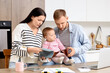 © Pixel-Shot - Sad young couple with their baby and empty wallets planning budget in kitchen