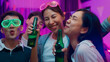 © tirachard - Diverse group adult Asia friend look at camera shooting video photo on mobile app dance and drink alcohol beer fun hangout party in living room night indoor home. Disco neon lights illuminating house.