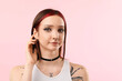 © New Africa - Portrait of beautiful young woman with different face piercings on pink background