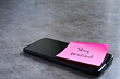 © Shannon Muranyi - 'Stay resilient' sticky note left on smartphone. The bright note stands out against the keys, symbolising motivation, productivity, and a focused mindset.