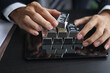 © Supitnan - Silver Trading and Commodity Market Analysis. Businessman’s hands interacting with silver bars and calculator for financial planning.