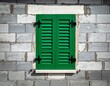 © juliusse - Closed green window shutters on gray brick wall of a new house under construction