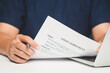 © meeboonstudio - Hands holding loan agreement document on desk