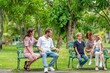 © BESTIMAGE - Peaceful family sitting on grass in park relaxing and looking away emotional bonding moment outdoors quiet time with parents and children together. Side View Portrait of Family of Four people