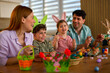 © djile - Happy family painting colorful easter eggs together