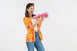 © sitthiphong - Songkran festival in Thailand, Cheerful young woman wearing summer wearing floral shirt with a pink toy gun isolated on white background.