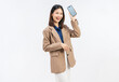 © sitthiphong - Confident young Asian businesswoman holding a smartphone with blank screen and smiling isolated on white studio background for mobile app and digital marketing concept