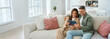 © insta_photos - Candid photo of happy middle aged couple using digital tablet relaxing on couch at home. Smiling mature man and woman holding tab browsing internet on pad device sitting on sofa in living room.