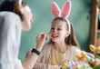 © Konstantin Yuganov - Happy Mother and Daughter Painting Faces for Easter Celebration at Home