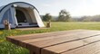 © Adine - Camping Tent with Wooden Deck in Field.