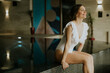 © BGStock72 - Young woman enjoys time near a pool in a spa setting during daylight hours
