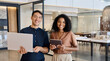 © insta_photos - Young happy professional work team of two diverse confident female and male partners employees business people man and woman standing together in office looking at camera, corporate portrait.