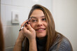 © Zoran Jesic - Woman applying eyebrow pencil in bathroom mirror