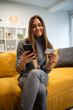 © Zoran Jesic - Young woman shopping online using phone and credit card