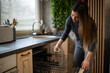 © Zoran Jesic - Woman loading dirty espresso cup into dishwasher